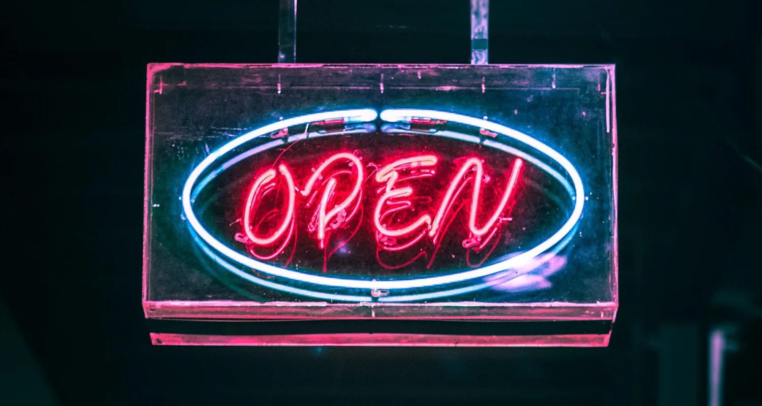 Relacionamento aberto: mitos e verdades - Dr. JONES. Foto de placa de néon, em que se lê "Open", em alusão aos relacionamentos abertos.